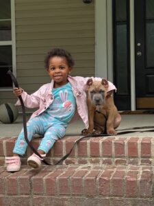 Child sitting on steps with puppy.